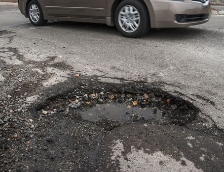 Big pothole caused by freezing and thawing during spring season