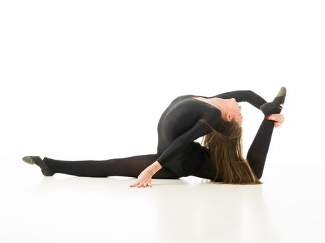young professional gymnast posing in split and stretching, on white background