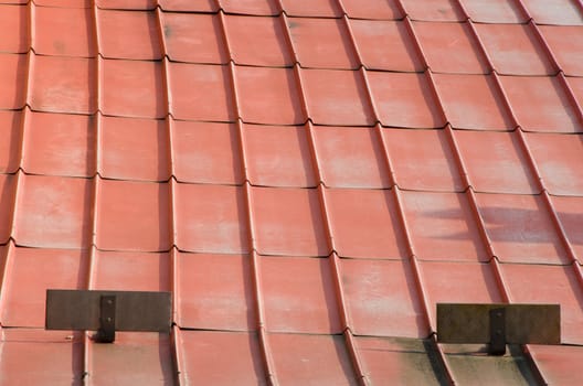 Old rusty metal orange roof on villa.