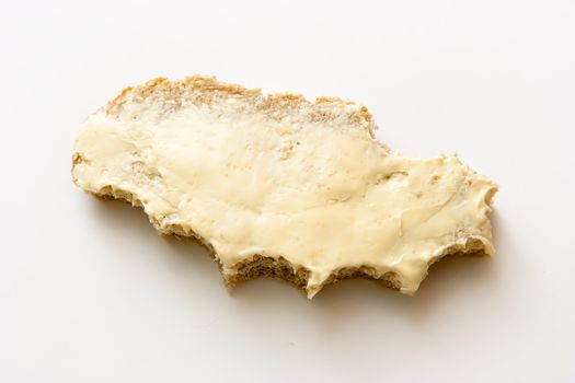 Bitten off a sandwich. Bread and butter on a light background