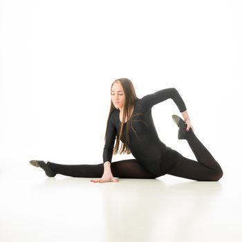 beautiful caucasian female gymnast doing split and stretching exercise, on white background