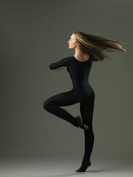 dancer performing a pirouette on grey background