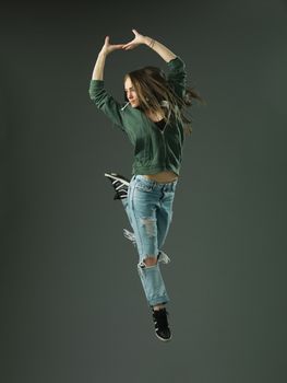 modern style dancer jumping against grey studio background