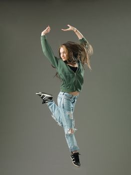modern style dancer jumping against grey studio background
