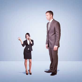 High businessman looking down at little woman using phone. Clouds and cement surface as background. Business concept