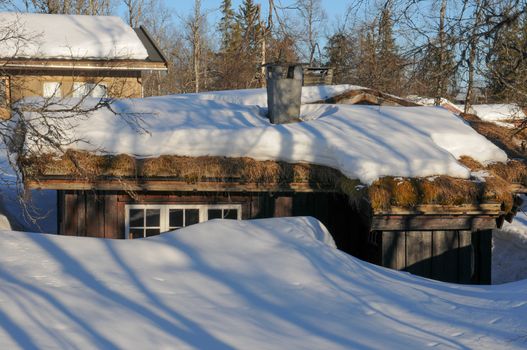 Cottage with melting snow on the roof