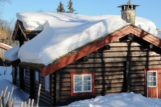 Cottage with melting snow on the roof