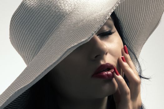 Young long-haired woman in a big white hat in the French style