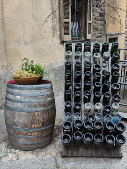 Old handmade Wine barrel and bottle outside a bar in Italy