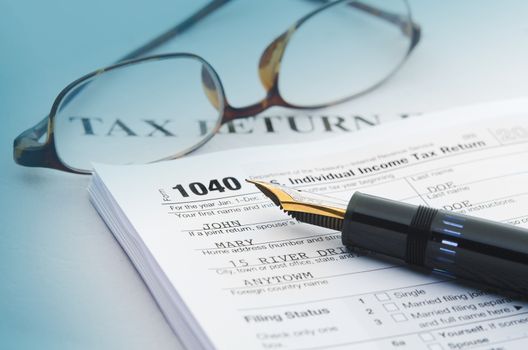 Tax accounting 1040 US Tax Form, with calculator, pen and glasses