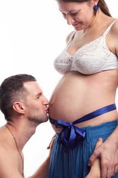 Happy father kissing the belly at his wife over white background