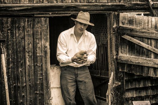 Young Farmer and a Chicken at the Farm