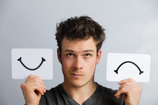 Portrait of a Questioning Man Holding Happy and Unhappy Survey Mood Board