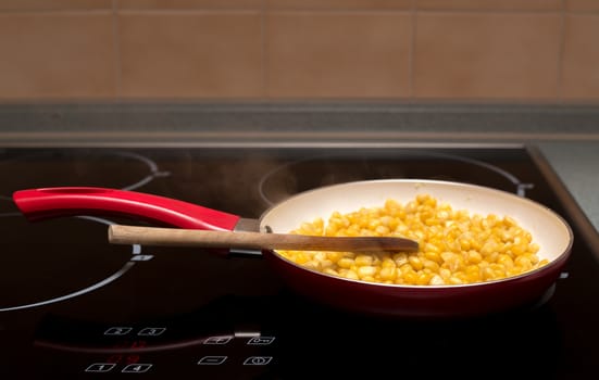 macro of cooking sweet conn with wooden spoon