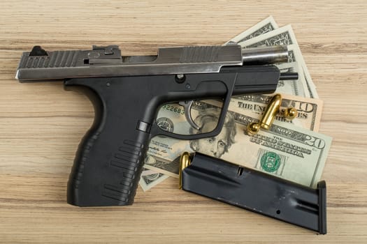 detail of gun with bullet on US dollar banknotes, crime or corruption concept