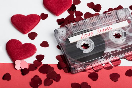 Audio cassette tape on red backgound with fabric heart, Valentine postcard. Love concept with evelope