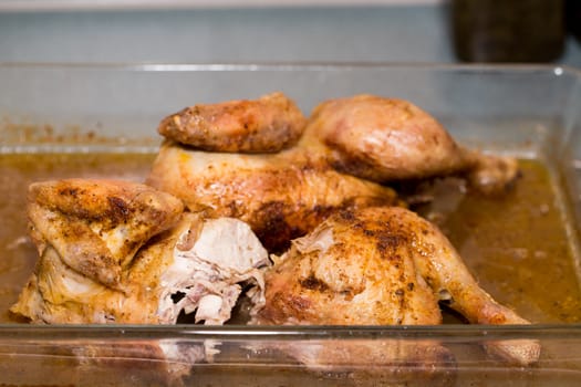 Roasted pieces of fresh chicken on pan with shallow focus