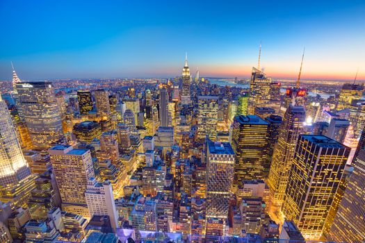 New York City. Manhattan downtown skyline with illuminated Empire State Building and skyscrapers at dusk seen from Top of the Rock observation deck. 