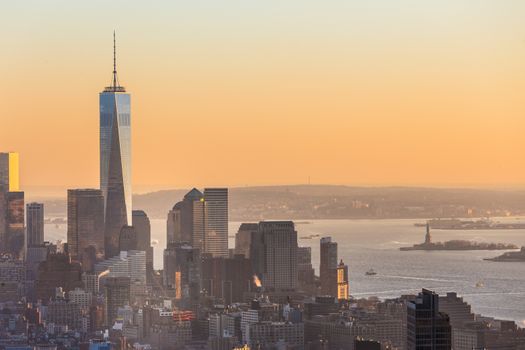 New York City. Manhattan downtown skyline with illuminated Empire State Building and skyscrapers at sunset seen from Top of the Rock observation deck. Vertical composition Fish eye lens shot.