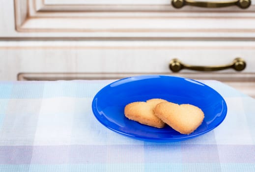 Two sweet heart cookies on blue plate 