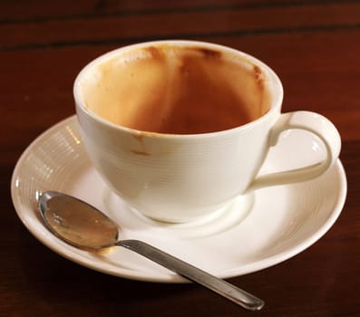 Empty used coffee cup on wooden table