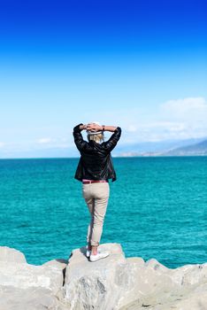 The back of an attractive young woman looking at the ocean view