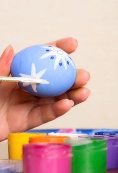 Young woman painting Easter eggs