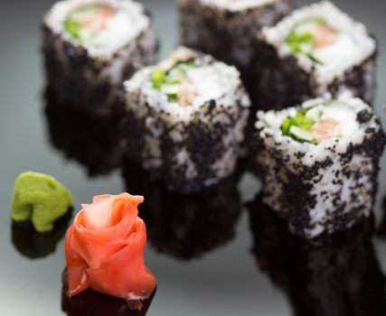 Japanese cuisine: sushi roll on black plate