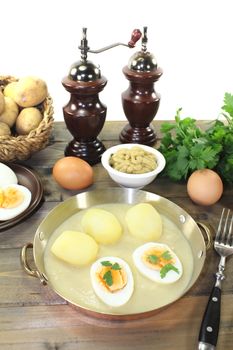 fresh sharp mustard eggs with sauce, potatoes and parsley