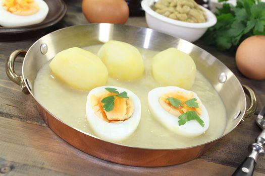 fresh mustard eggs with sauce, potatoes and parsley