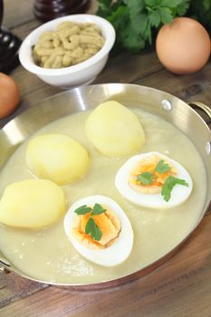 sharp mustard eggs with sauce, potatoes and parsley