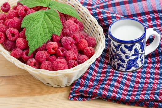 Raspberries with milk on wooden table