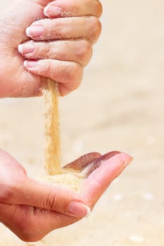 Young woman with sand in hands