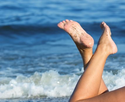 Close up of female feet on sandy beach