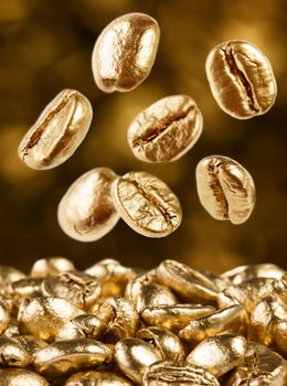Gold coffee beans on brown background falling down