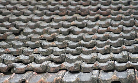 The roof of an old house covered with gray tiles.