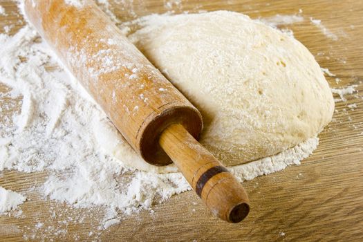 Dough with rolling pin on wooden table