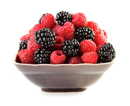 Saspberries and blackberries in plate isolated on white background
