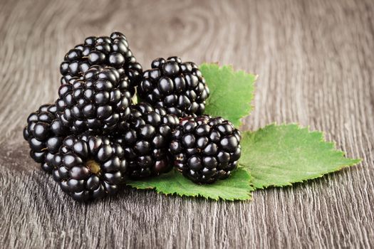 Blackberries with leaf on wooden background