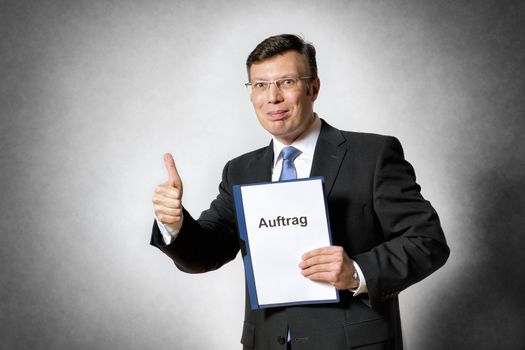 Image of happy businessman with german contract and thumb up