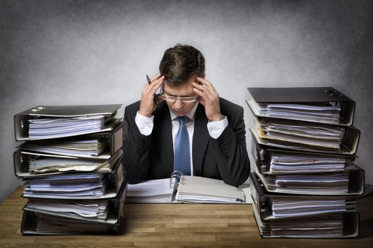 Overworked businessman with lot of files on his desk