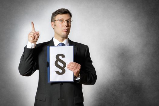 Businessman in dark suit holds a folder with a big paragraph sign