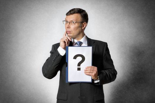 Businessman in dark suit holds a folder with a big question mark