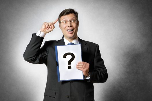 Businessman in dark suit holds a folder with a big question mark