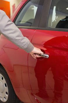 Man holding a car door handles at new car showroom