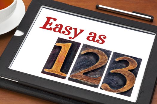 easy as 1, 2, 3 concept - text and numbers in letterpress wood type on a digital tablet