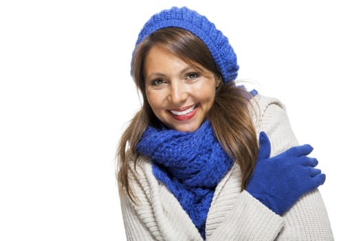 Close up Pretty Smiling Young Woman Wearing Winter Knit Outfit with Blue Bonnet, Scarf and Gloves. Captured in Studio with White Background While Looking at the Camera.