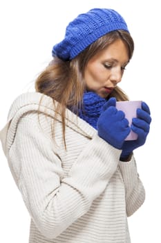 Close up Pretty Smiling Young Woman Wearing Winter Knit Outfit with Blue Bonnet, Scarf and Gloves. Captured in Studio with White Background While Looking at the Camera.