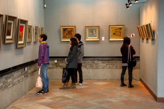 CANTON, CHINA - MARCH 8, 2011: Unidentified person admires Chinese paintings inside Chen Clan Ancestral Hall on 8th March in Guangzhou, China. 
