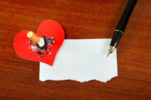 Cigarette in Heart Shape and Empty Paper on the Table